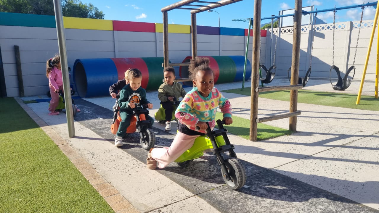 Children riding balance bikes at Ashron